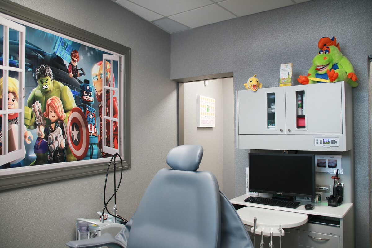 Smiling dental assistant and smiling boy in dental chair