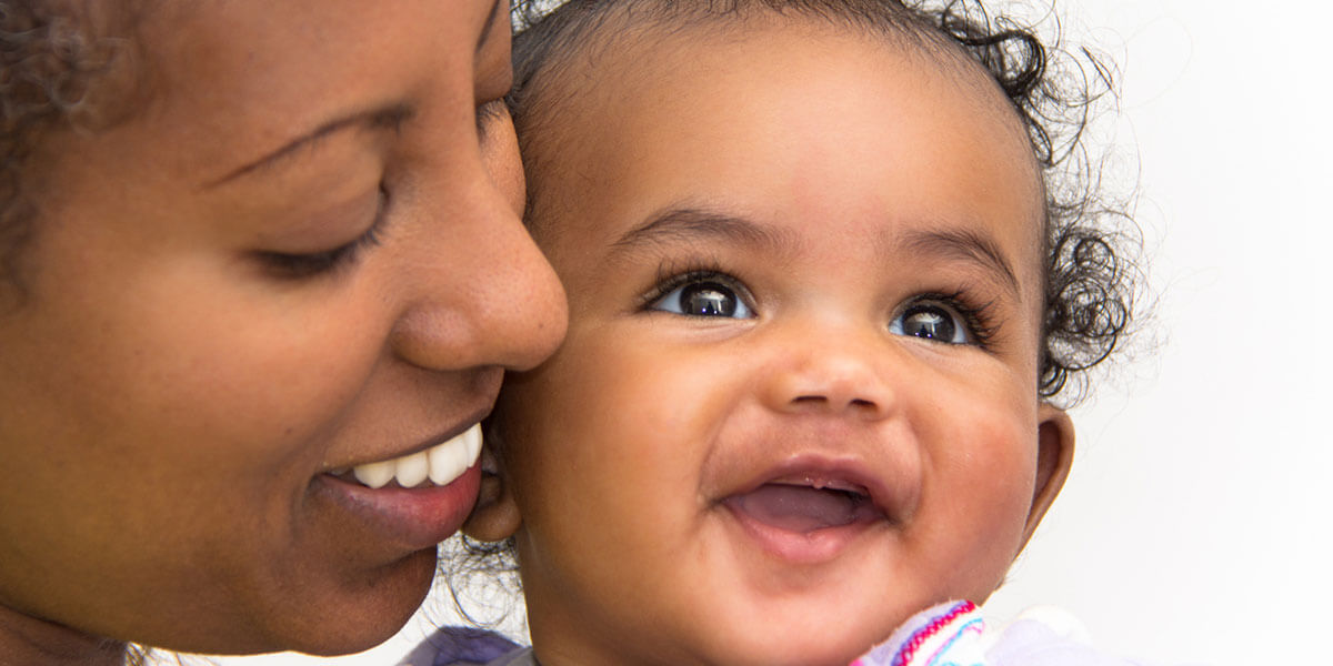 Smiling young woman with happy baby