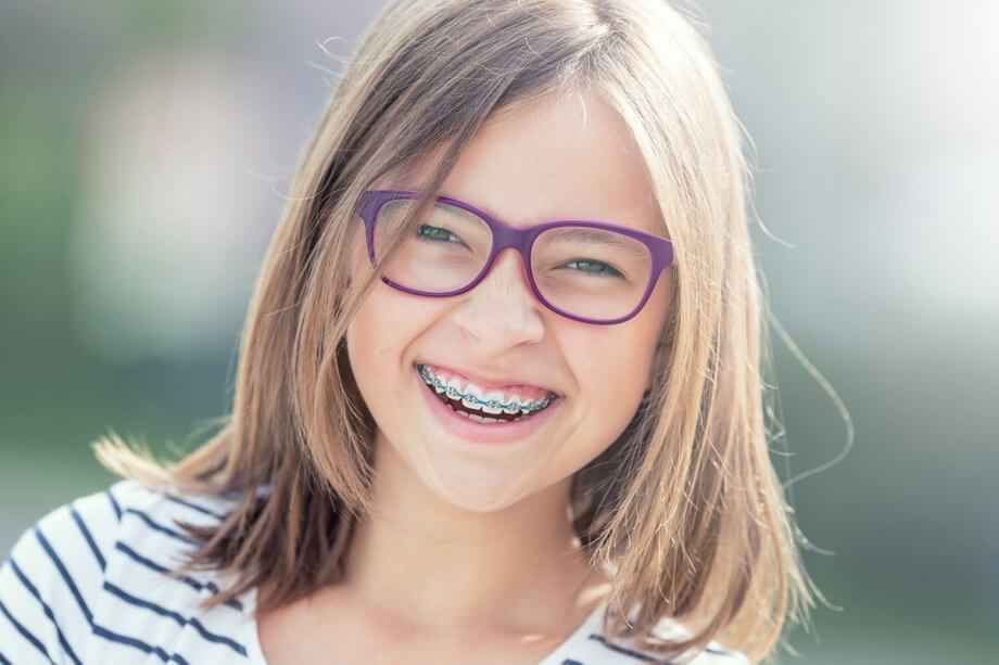 a girl smiles with braces