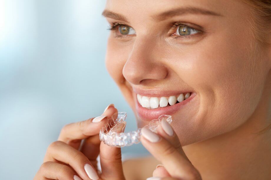 smiling woman with Invisalign tray