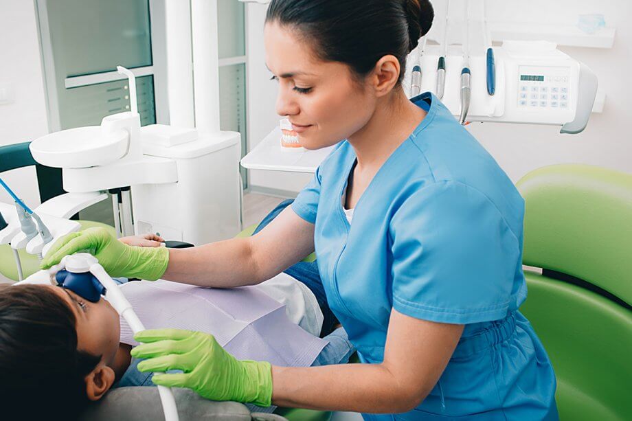 dental professional performs sedation for a child