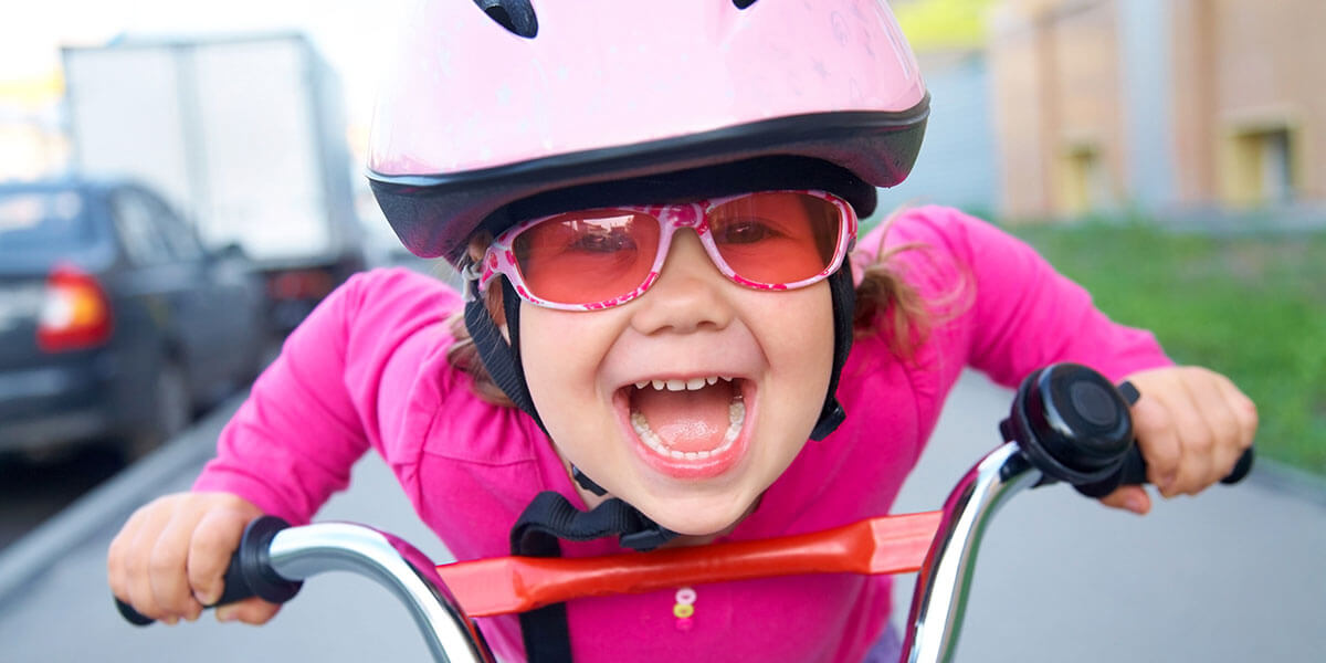 Young girl with pink helmet riding bike